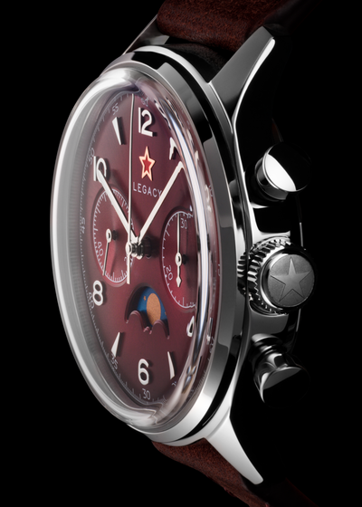 A close-up of a Seagull1963 Legacy Burgundy chronograph watch with a burgundy dial, silver-tone case, and wine red leather strap against a black background.